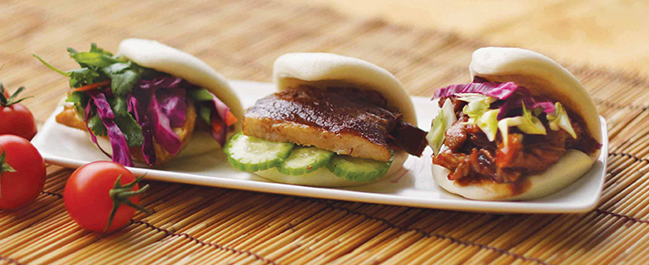 Plate of foodservice Amoy Asian Plain Folded Bun in a restaurant setting