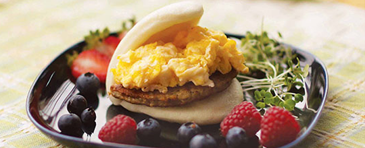 Plate of foodservice Amoy Asian Huevos Ranchero Bao in a restaurant setting