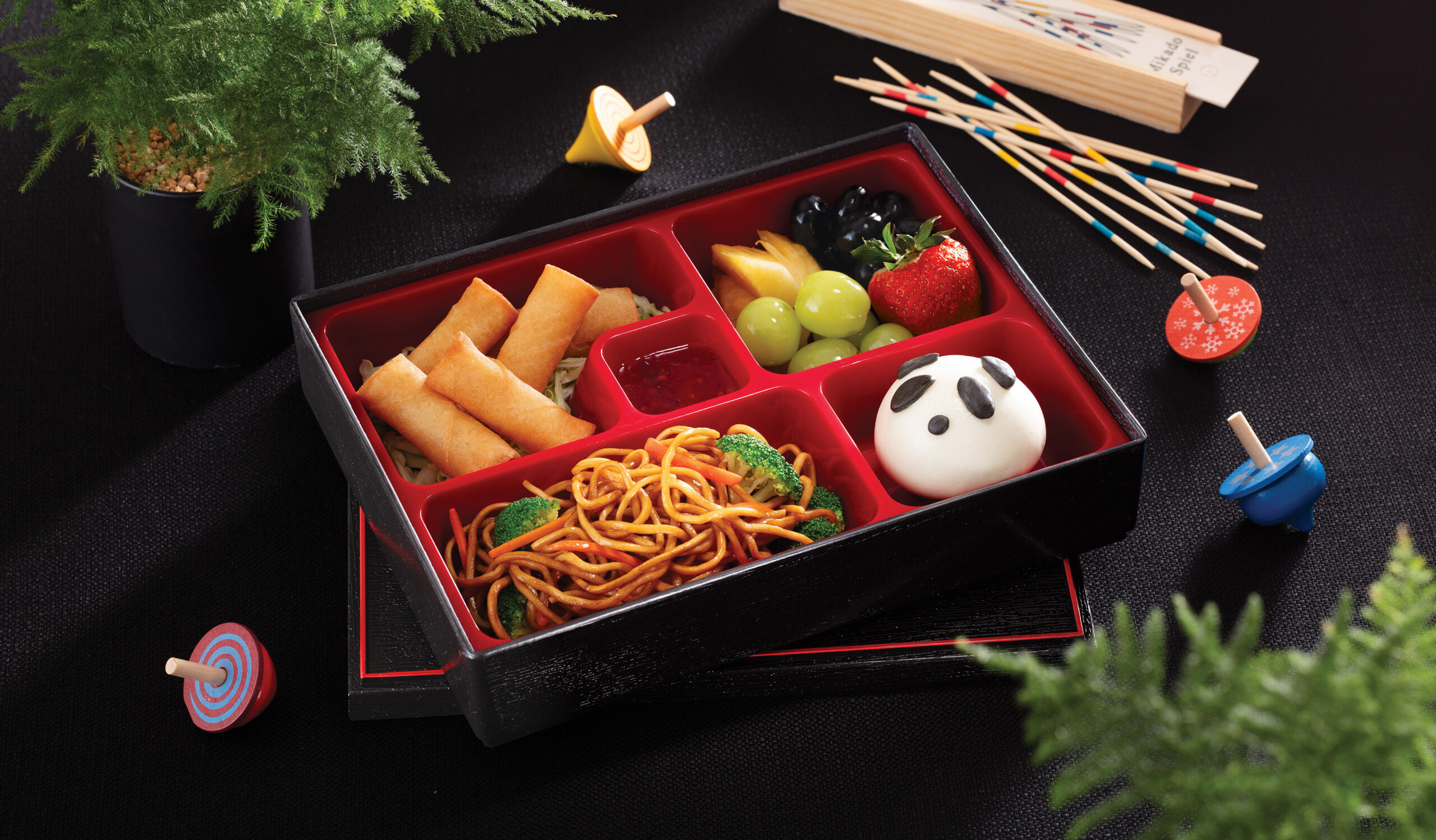 bento box of noodles, spring rolls and vegetables
